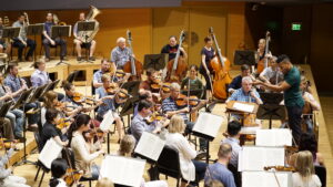 Conductor with orchestra at practice session